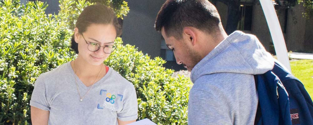 A student receives a flyer at a Health event